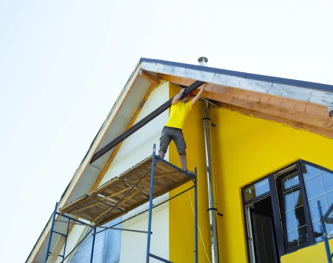 a man is working on a house with scaffolding photo